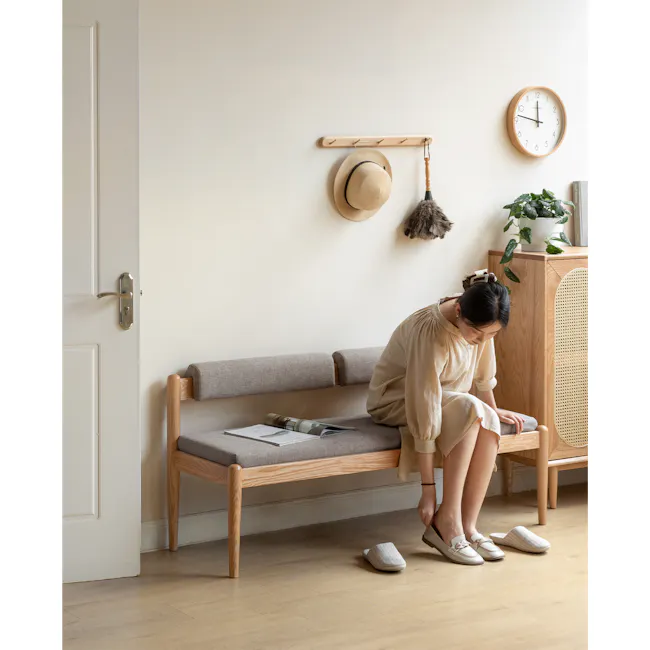 Niel Bench 1.45m - Oak, Chestnut - 3 - Wooden bench, woman sitting, beige dress, light wooden door, gray cushion, white
