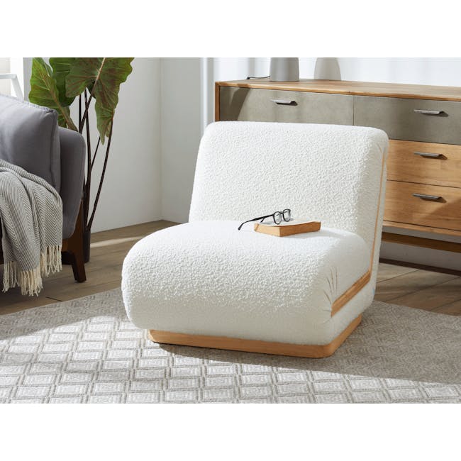 Eloise Lounge Chair - 5 - White textured armchair, wooden base, cozy reading nook, soft lighting, modern decor, gray throw