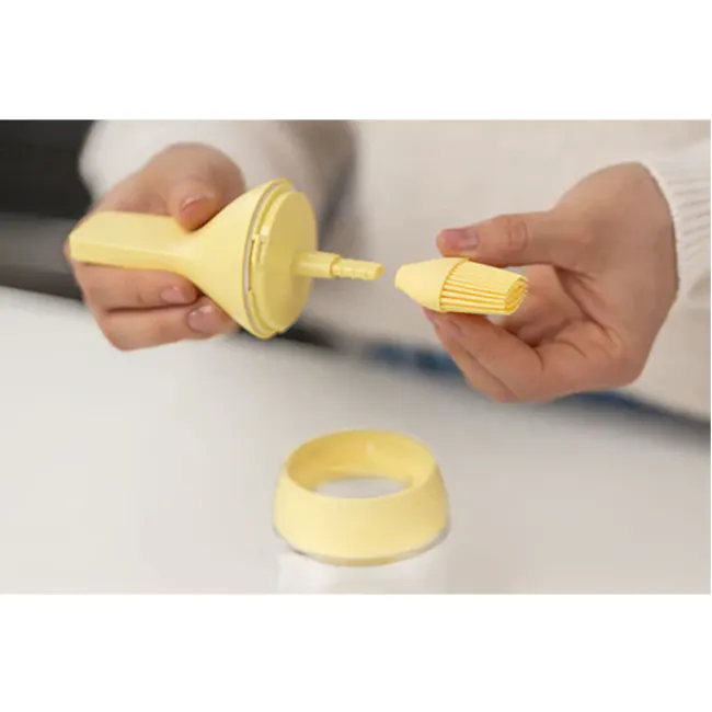 Zuutii Oil Dispenser with Brush - Lemon Yellow - 3 - Disposable toilet paper roll dispenser, yellow, person holding roll