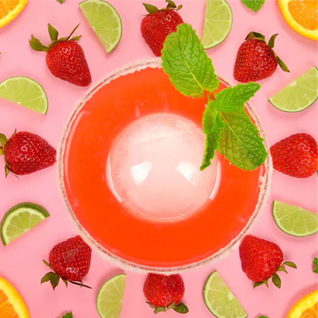 Zoku Ice Ball Mold (2 Pcs) - 7 - Strawberries, lime slices, orange slices, vibrant pink background, refreshing drink, fruity