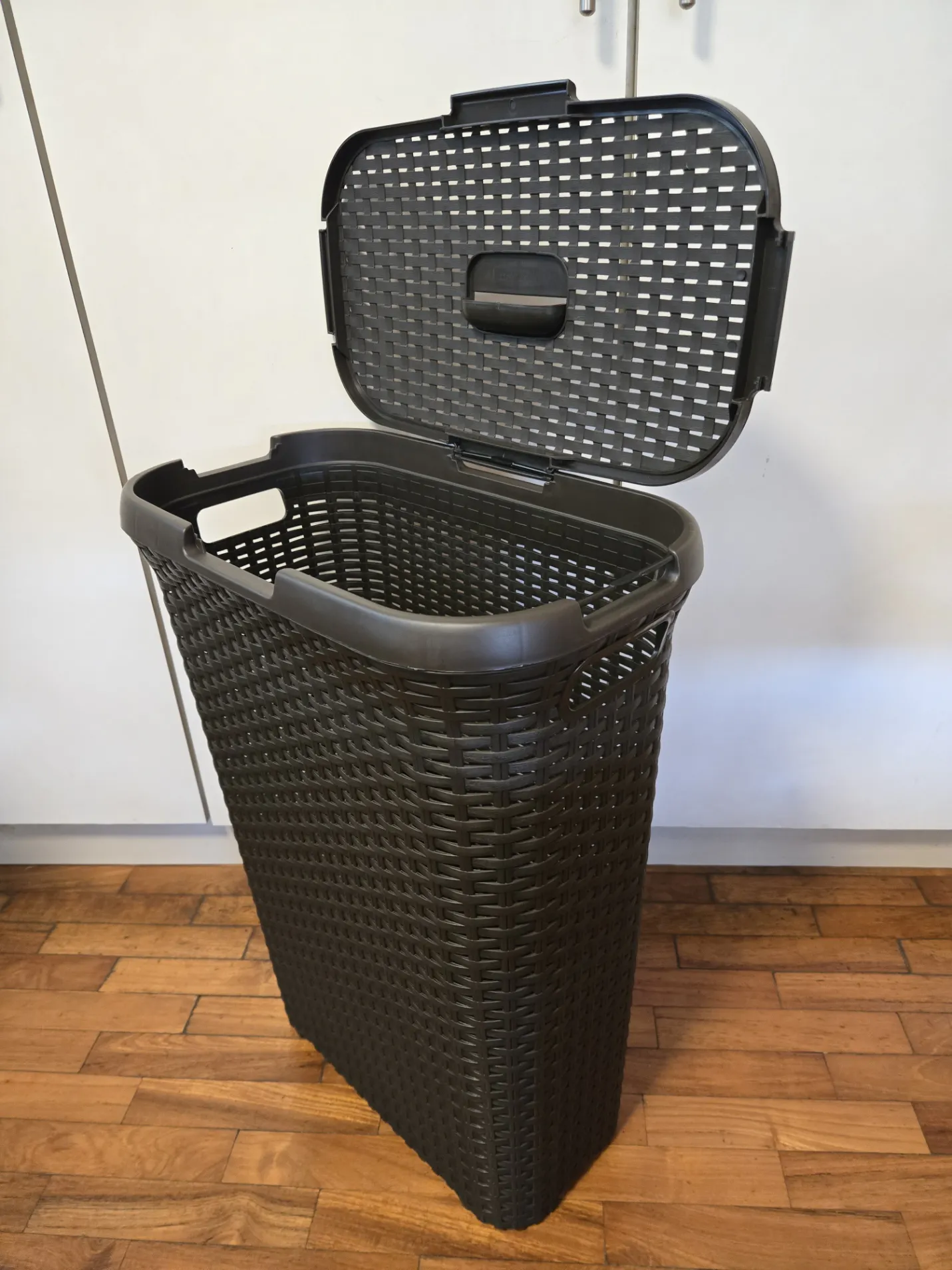Customer home photo 1: Real nice high quality rattan style laundry basket. Solid contruction. Lid hinge can be attached 2 ways, which is a great feature. Thin profile makes it good for small bathrooms. Wish I had bought 2!