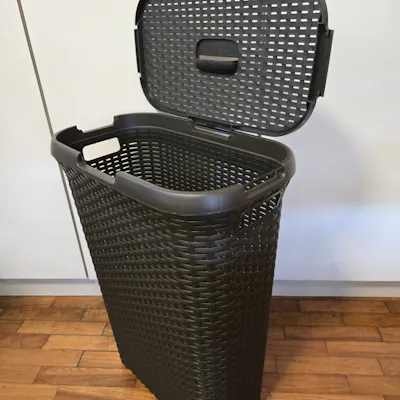 Customer home photo 1: Real nice high quality rattan style laundry basket. Solid contruction. Lid hinge can be attached 2 ways, which is a great feature. Thin profile makes it good for small bathrooms. Wish I had bought 2!