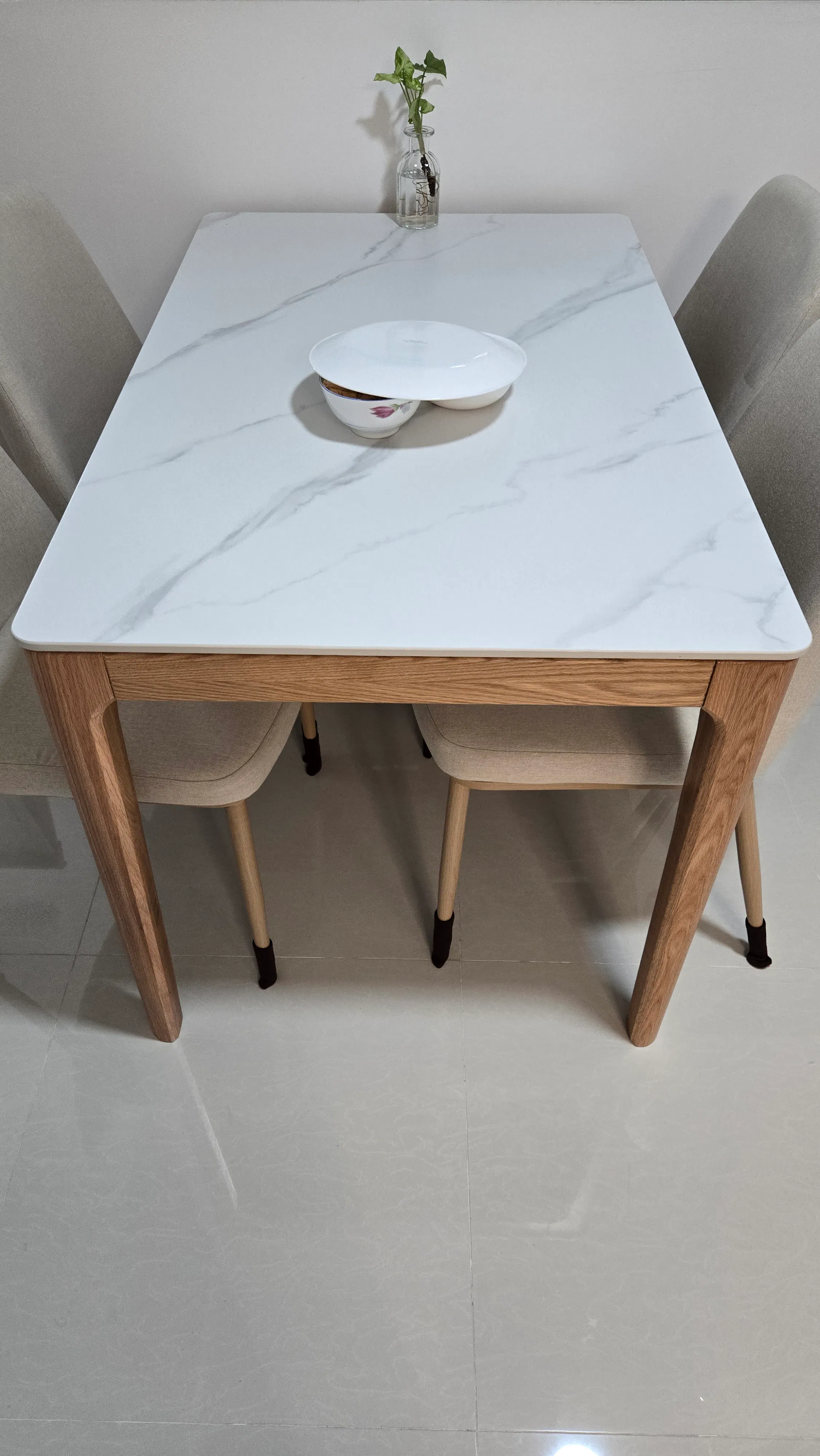 Customer home photo 11: Item received in good condition. The wood tone matches my built-in furniture. The quality for the wooden legs and sintered stone is also not bad. Installer secured the table top to the frame with silicone double sided adhesive.