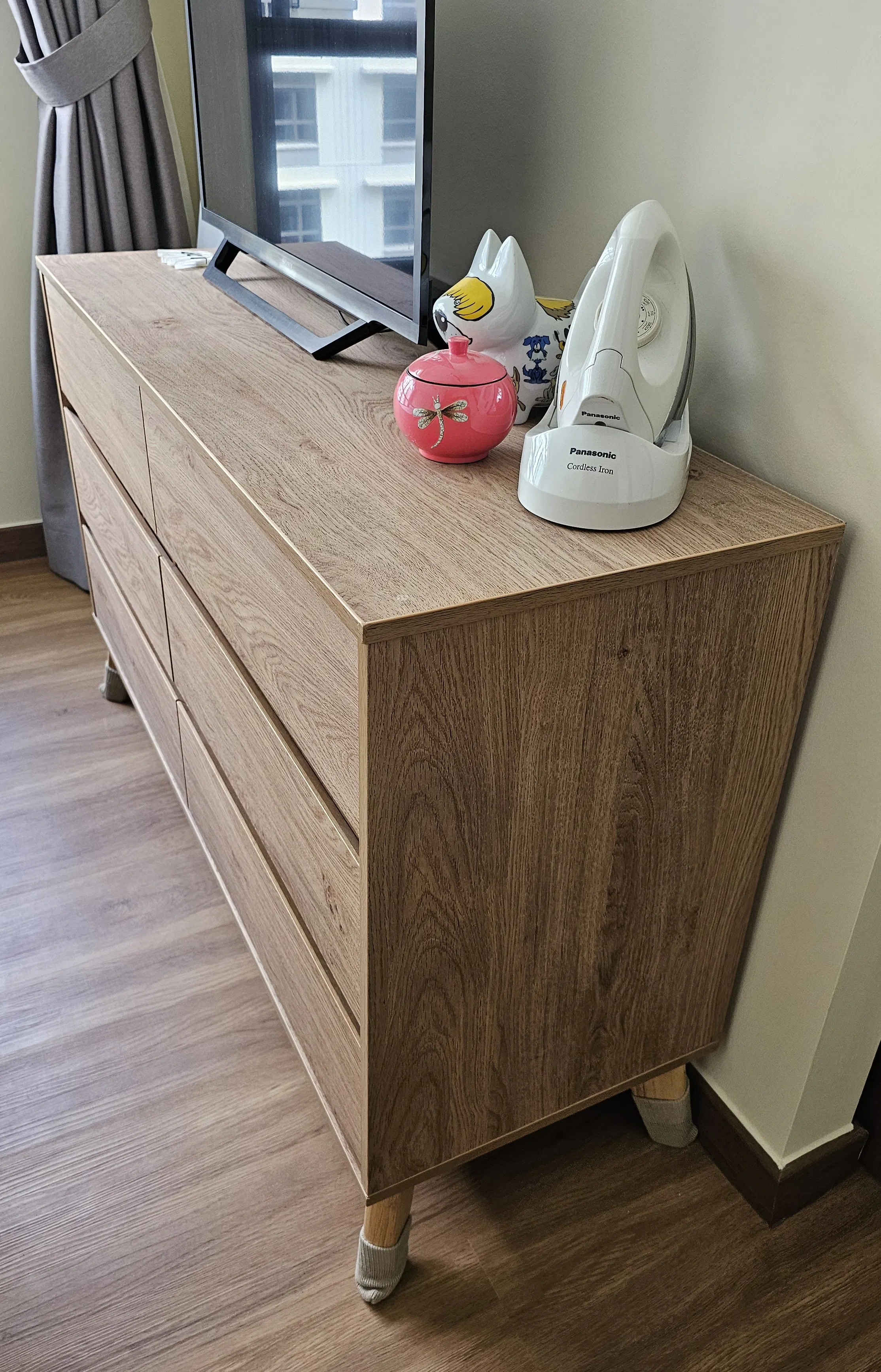 Customer home photo 4: The soft closing of the drawers is great to have. This piece looks lovely with the natural grains of the wood and it matches my flooring. The height makes it just about right for placing a TV on.
