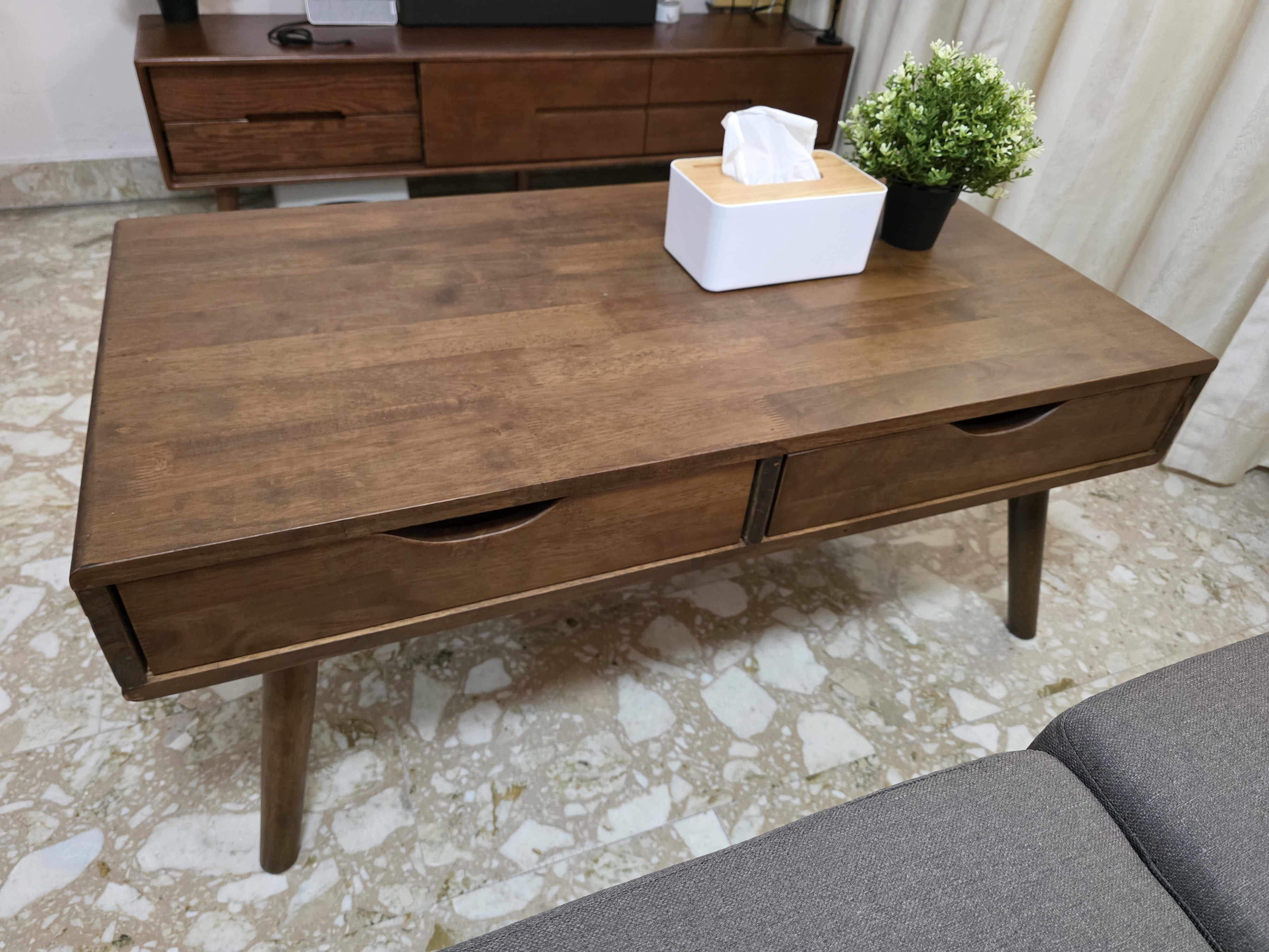 Customer home photo 1: This is a little bulky, but rock solid wood. Has 2 drawers allow clearing mess on the table. Fits nicely with 2 seater sofa.