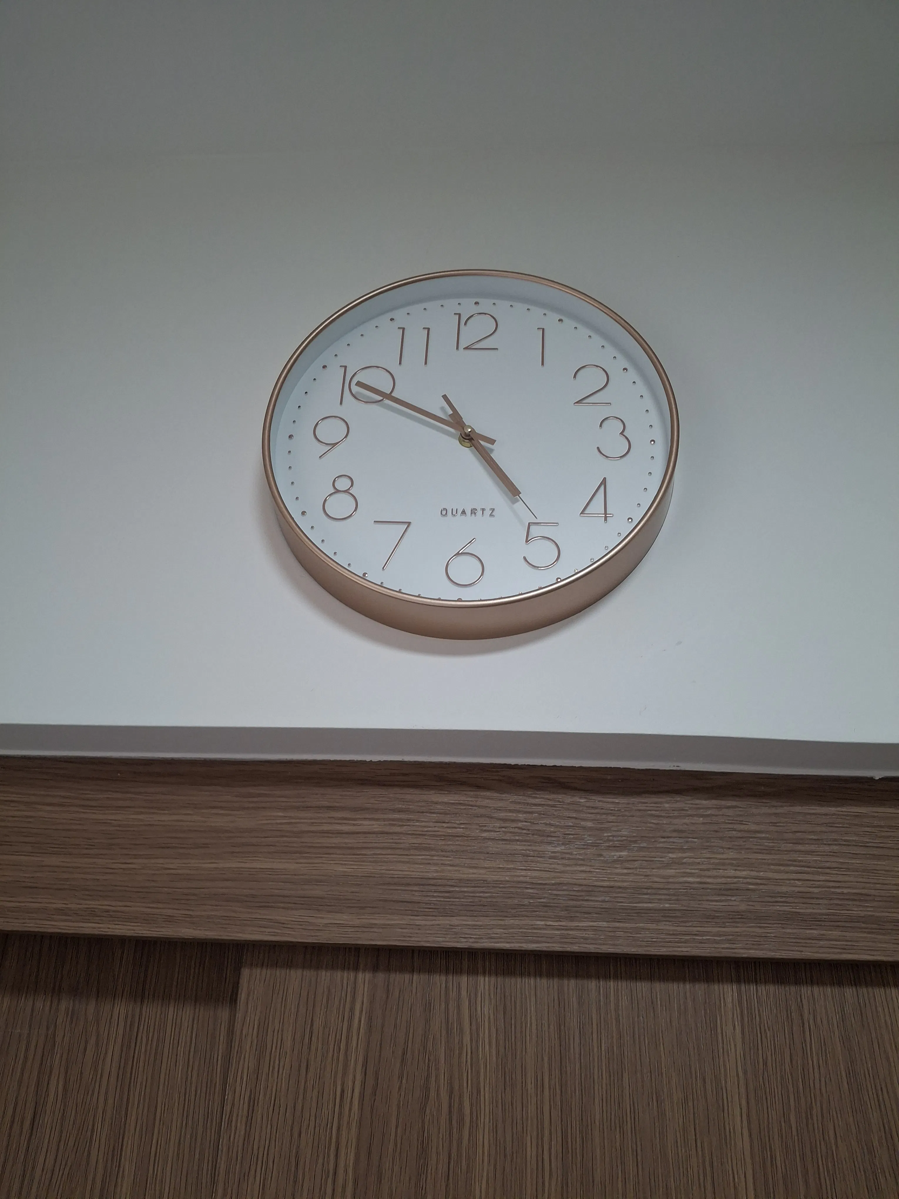 Customer home photo 5: Looks nice especially the rose gold bezel, clock hands and numbers. I like rose gold and am trying to sneak in rose gold items to lend my new place a more luxe feel. Took one star off because the clock is fast by 4 min