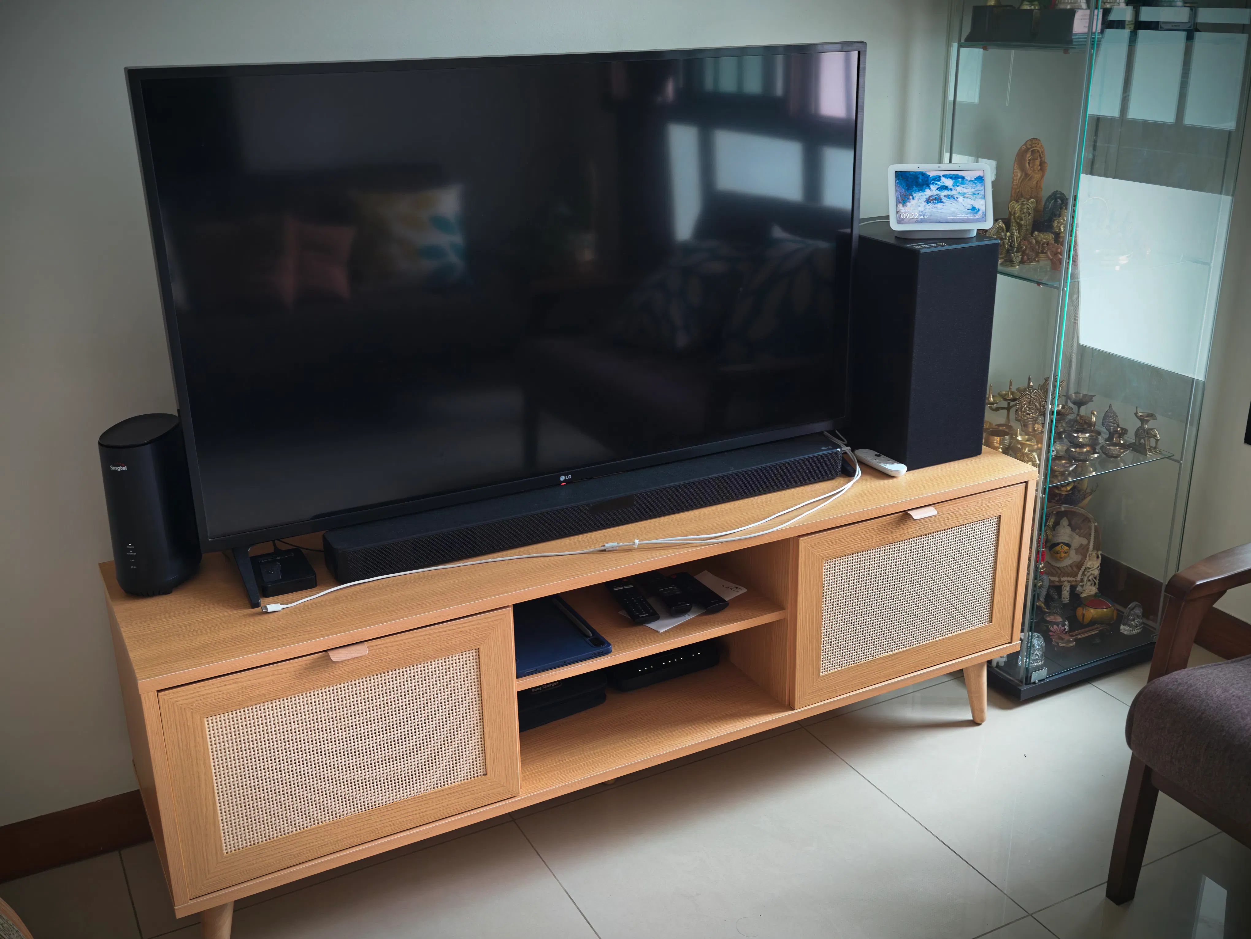 Customer home photo 1: I like the ratan style and the color combo of the wood. But design wise and finish wise the product could have been better.  Cannot move as the middle leg starts creeking. Need to lift up to move. Otherwise the product is fine. Fits my 50inch perfectly including the SUb woofer