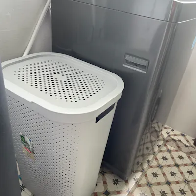 Customer home photo 5: Nice laundry basket. Right size for 2 person. Nice slim design that fits in the space in between the pipe and washer.