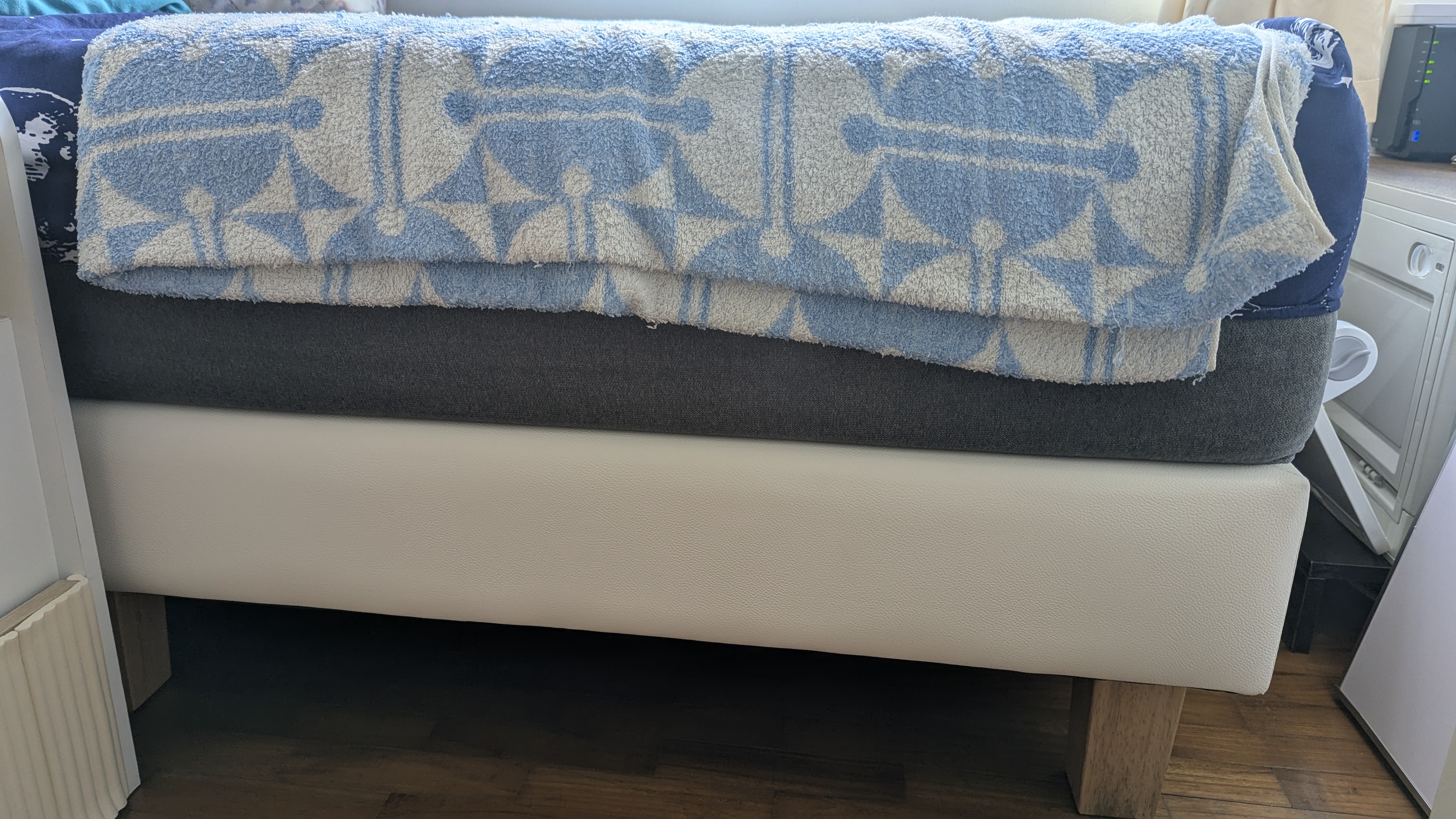Customer home photo 1: Simple and of good height. Stable and does not creak like the previous bed frame I have. Lo ve this! 😍 The quality for this price is awesome. The white faux leather surface is easy to clean with just wet wipes. 

Sorry for the not so nice picture😅My bed position does not allow me to get a good one.