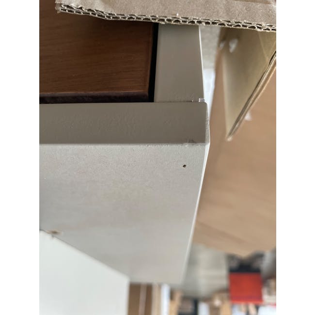 (As-is) Brexley Coffee Table - 11 - Close-up view of a wooden cabinet corner, Construction materials and tools in the