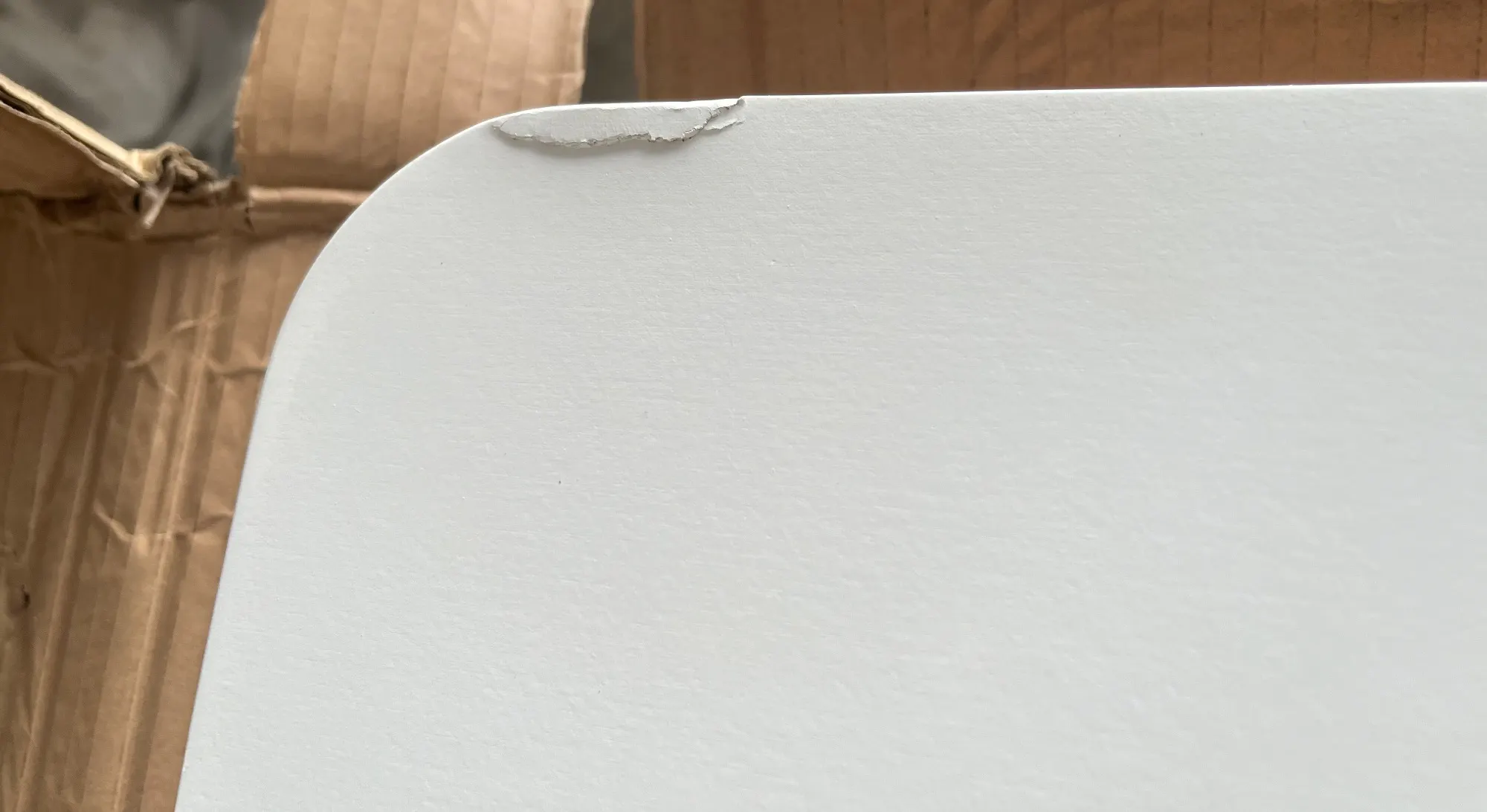 (As-Is) Charmant Dining Table 1.4m - Natural, White - 6 - 9 - White surface, cardboard box, torn edge, rough texture