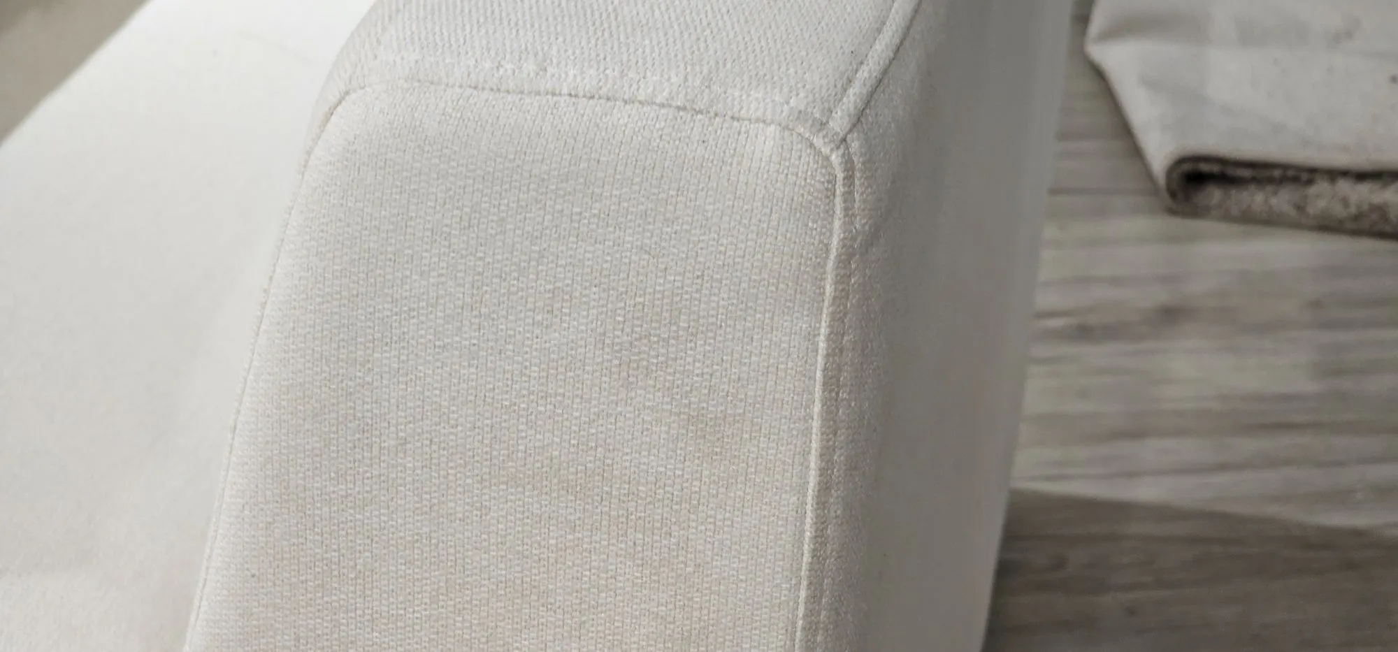 (As-is) Russell Armless Unit - Oat (Eco Clean Fabric) - 14 - White fabric sofa, textured upholstery, soft lighting