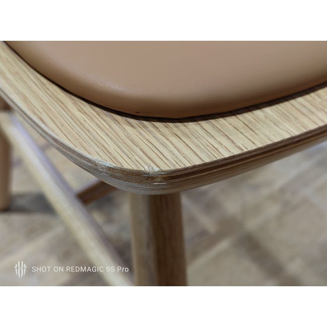 (As-is) Jensen Chair - Oak, Tan (Faux Leather) - 3 - Close-up view of a wooden chair's edge, Smooth, curved wooden chair